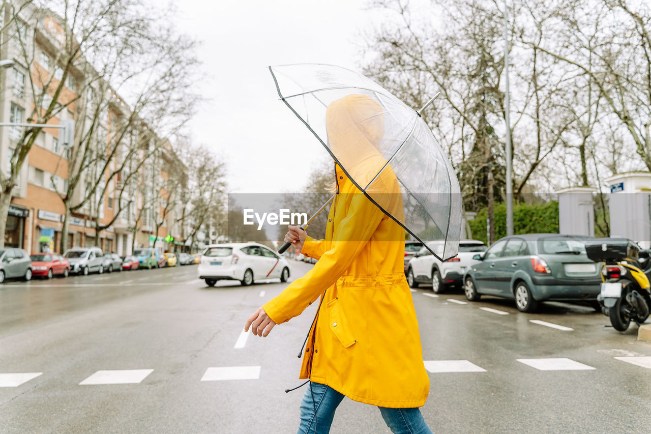 Rear view of woman holding umbrella