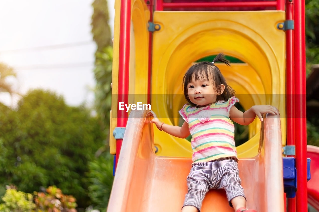 Baby girl on slide in playground