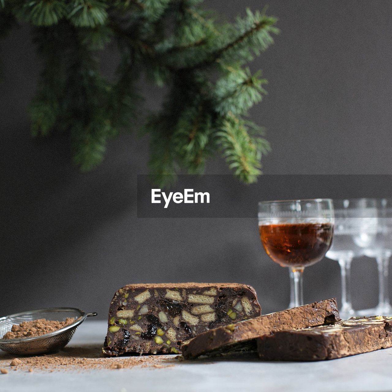 CLOSE-UP OF WINE GLASS ON TABLE AGAINST TREES