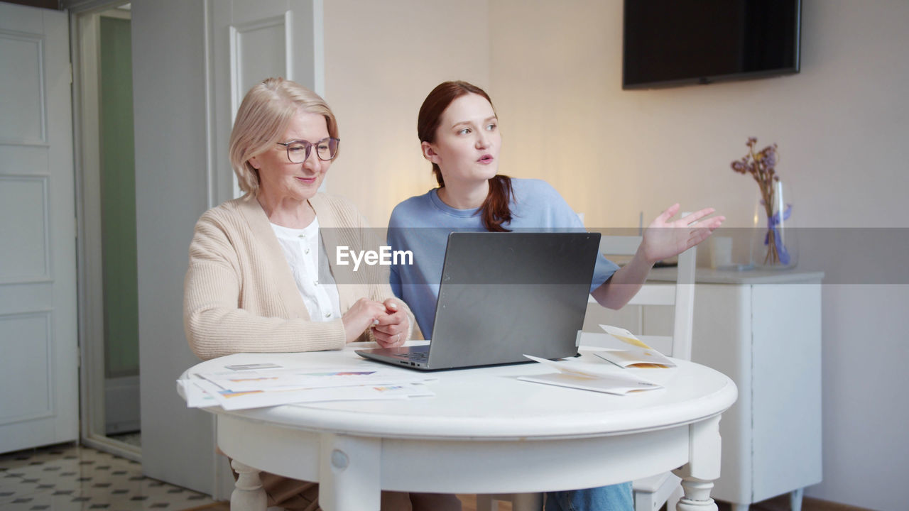 Smiling woman using laptop at home