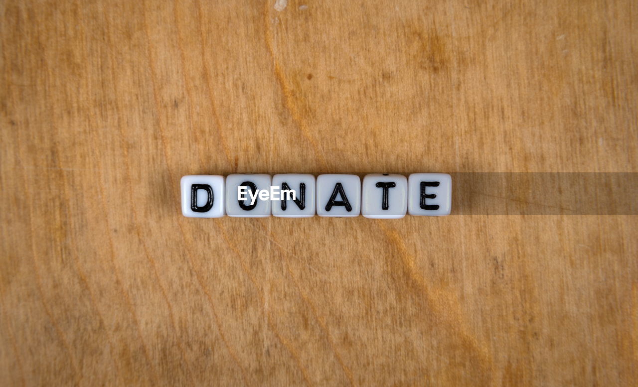 CLOSE-UP OF SIGN BOARD ON TABLE