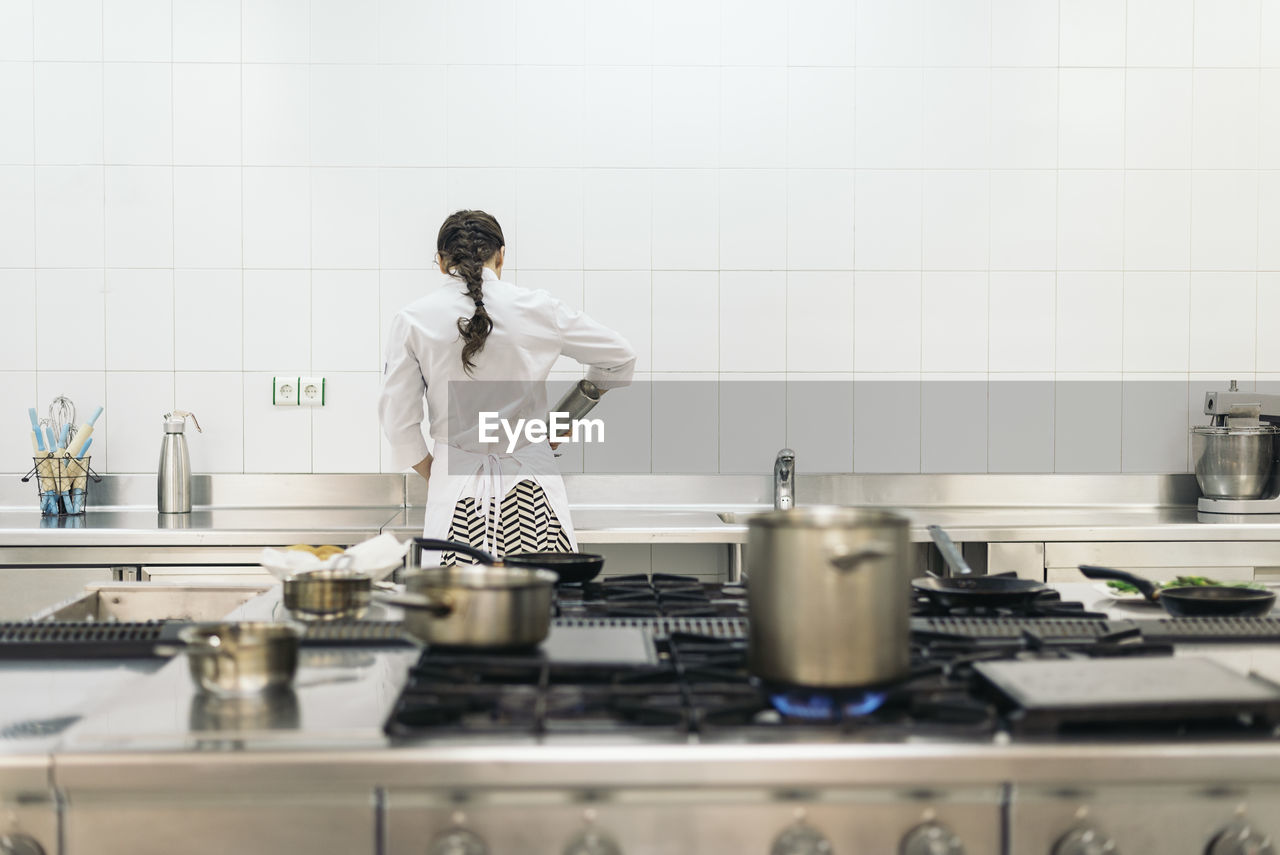 portrait of female friends with arms crossed in kitchen