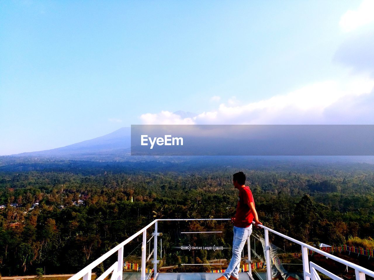 Young man standing on observation point looking at landscape