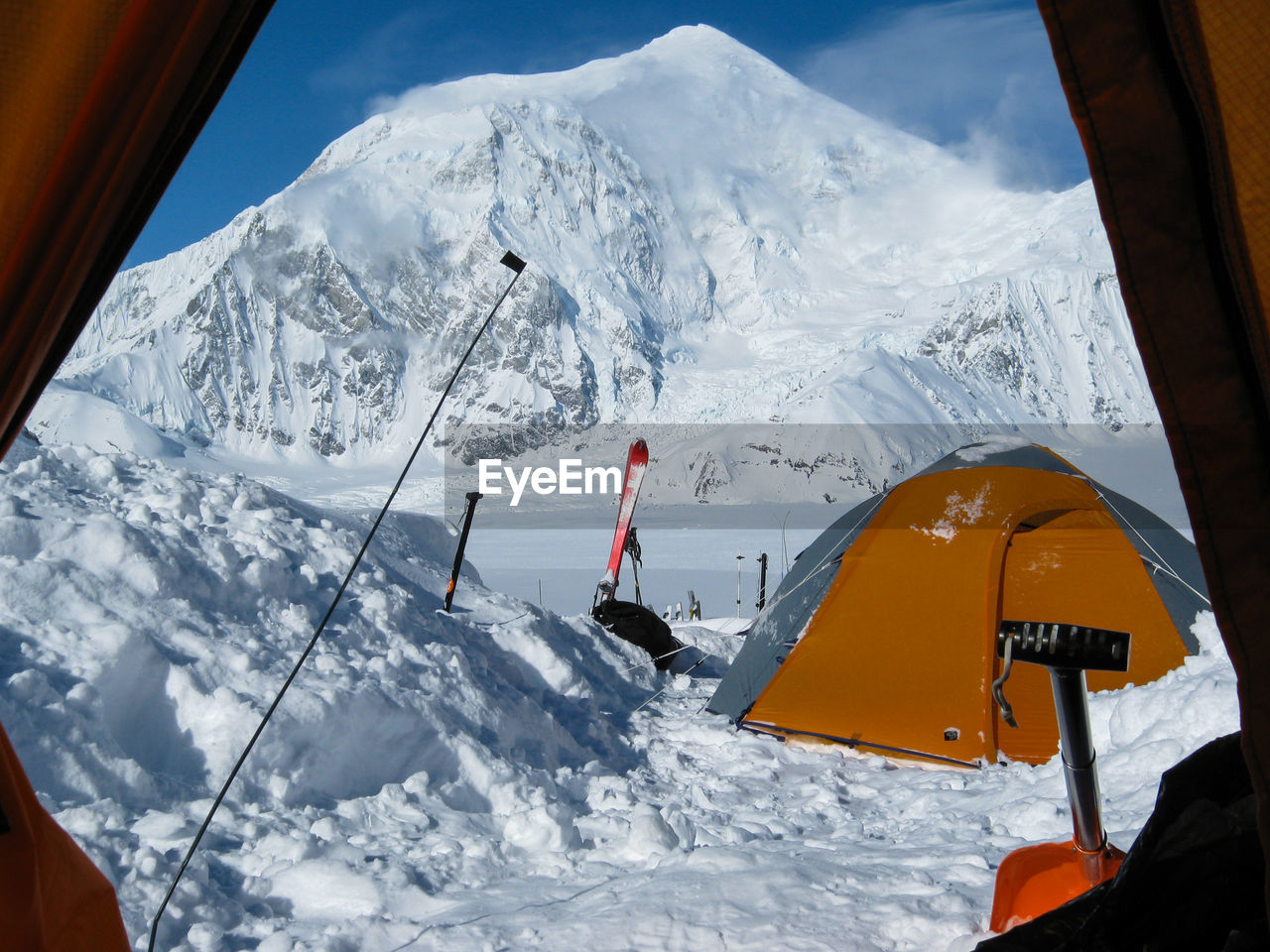 Looking out a mountaineering tent in the snow at denali basecamp and mount foraker