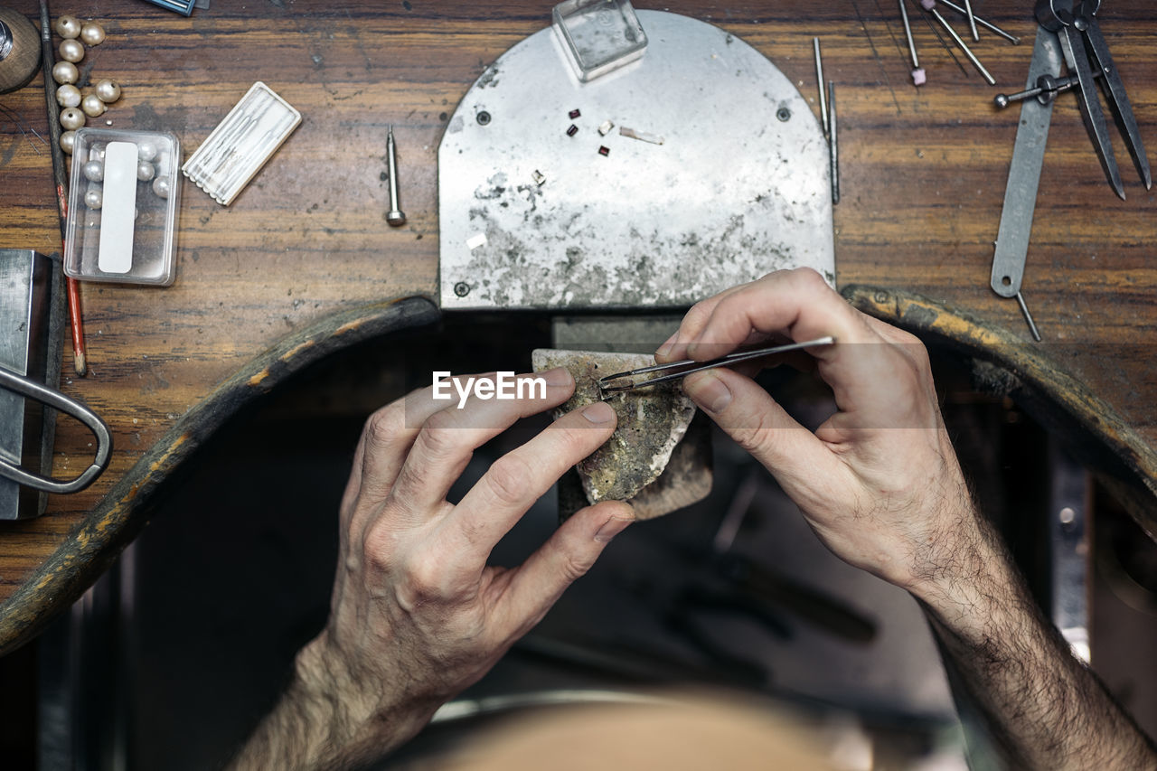 Cropped hand of worker working at workshop