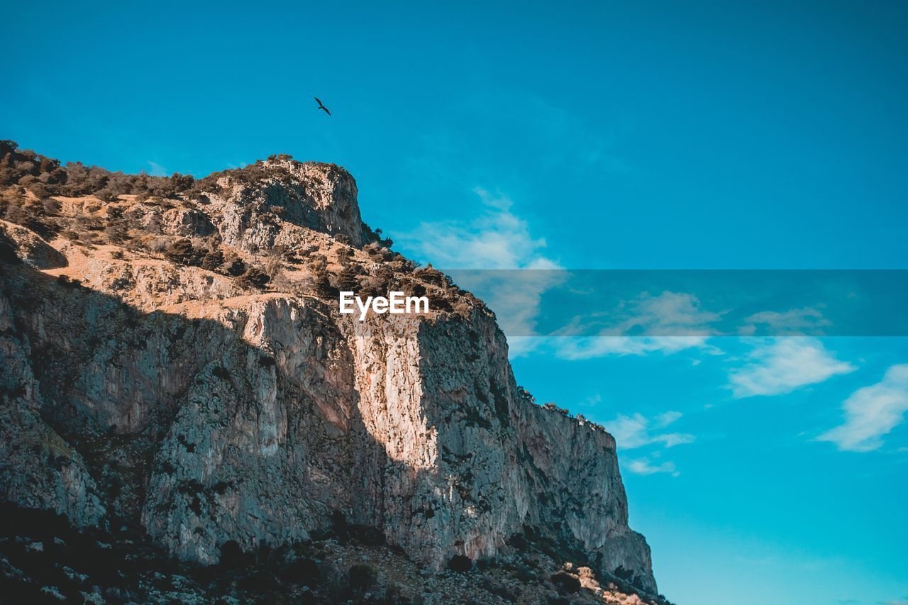 LOW ANGLE VIEW OF ROCK FORMATIONS AGAINST SKY