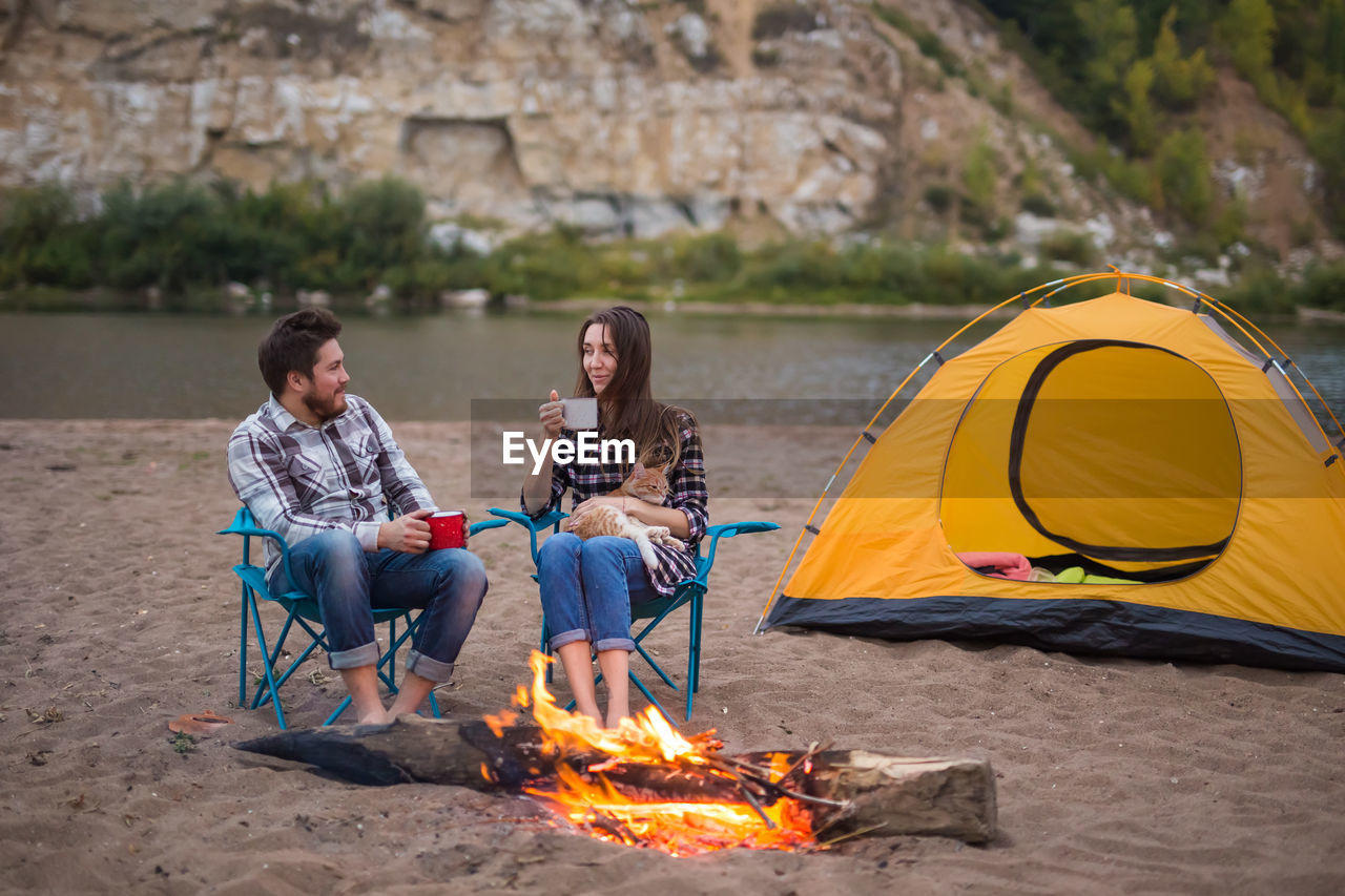 PEOPLE SITTING ON BONFIRE WITH FIRE