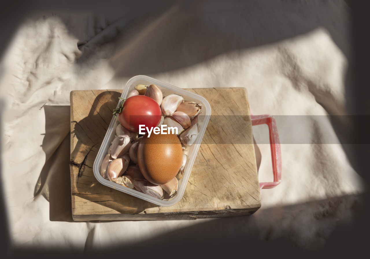 Egg, tomatoes and garlic in containers by selective focus shooting with copy space