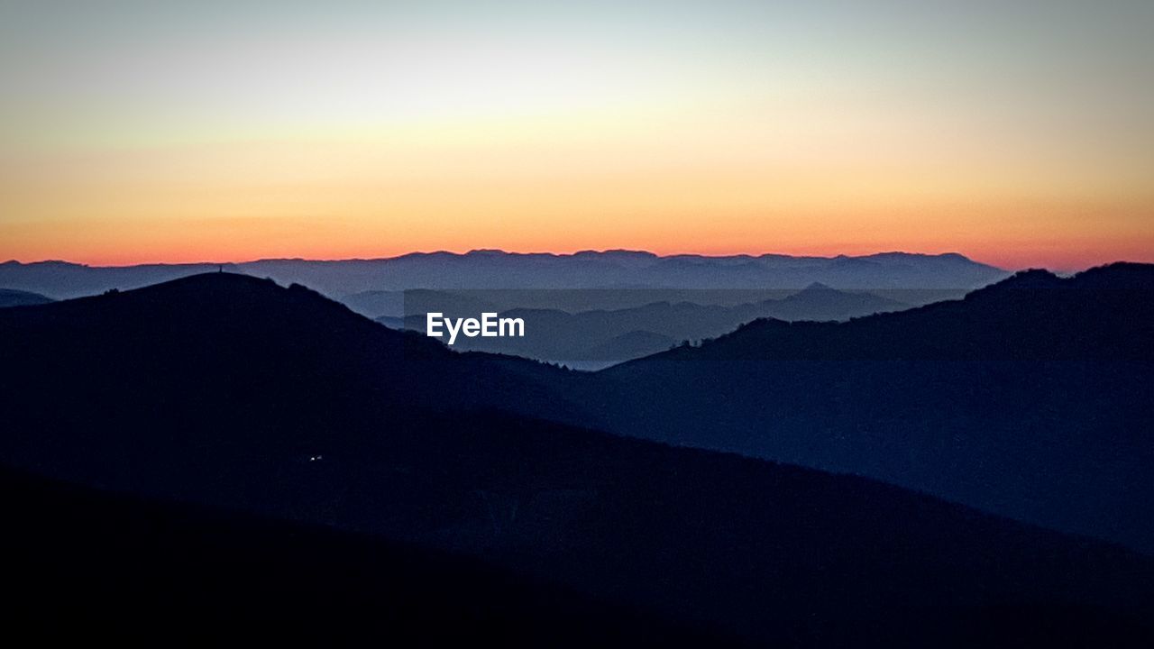 SCENIC VIEW OF SILHOUETTE MOUNTAINS AGAINST CLEAR SKY