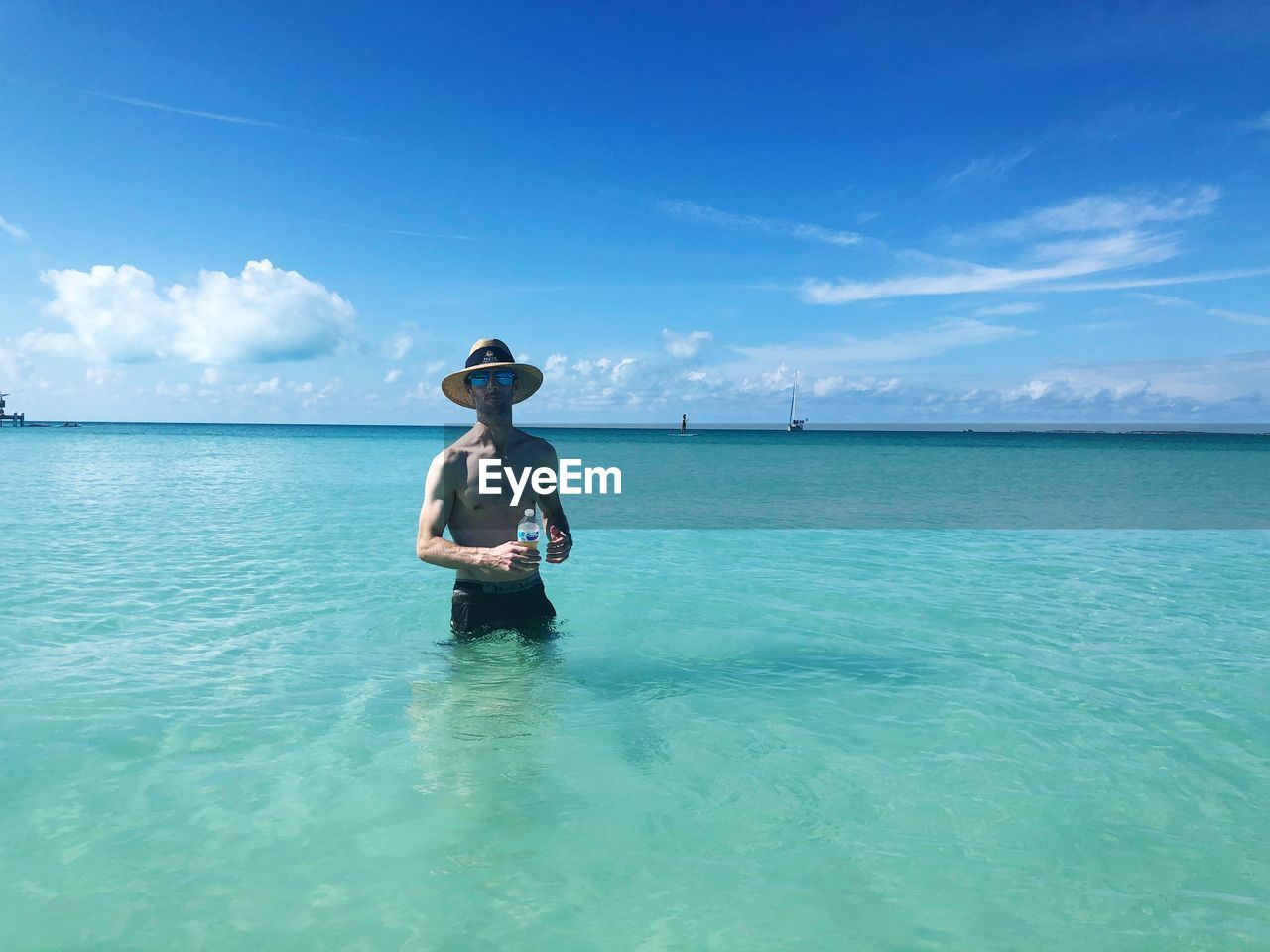 MAN IN BOAT ON SEA AGAINST SKY