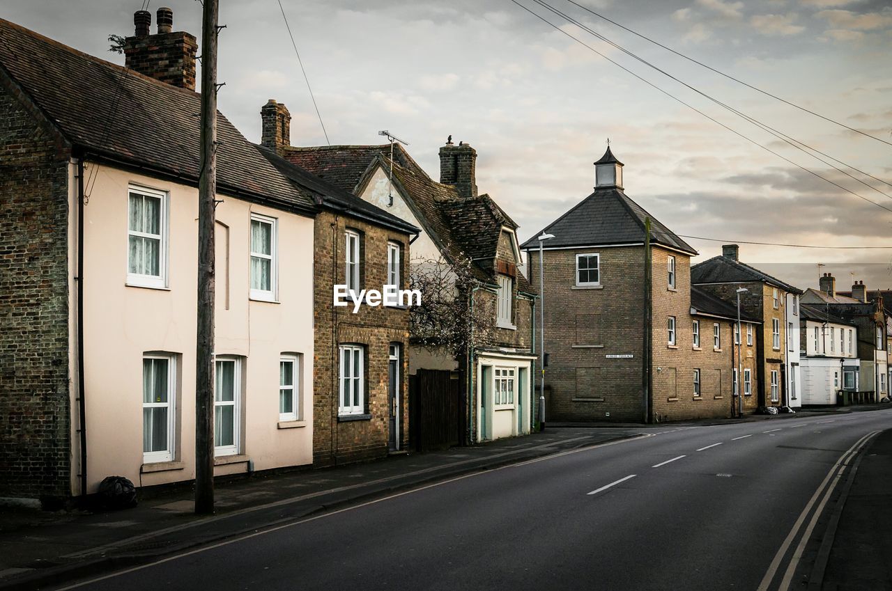 Empty road by houses in city