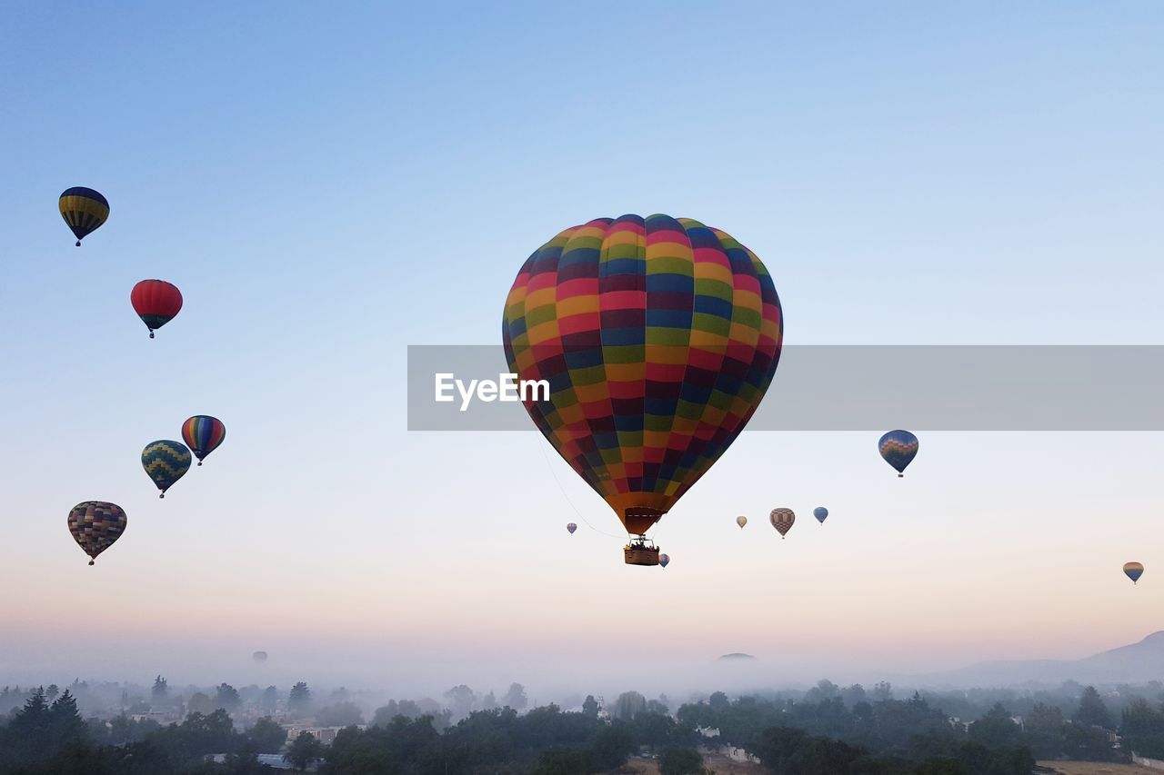 Low angle view of hot air balloons against sky during sunrise