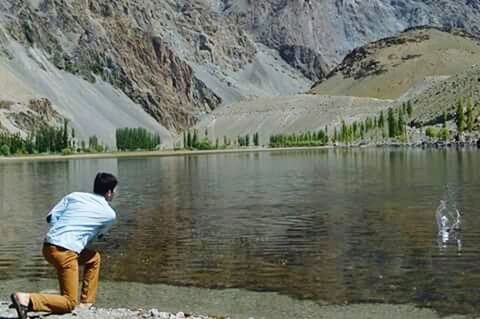 MAN STANDING IN LAKE