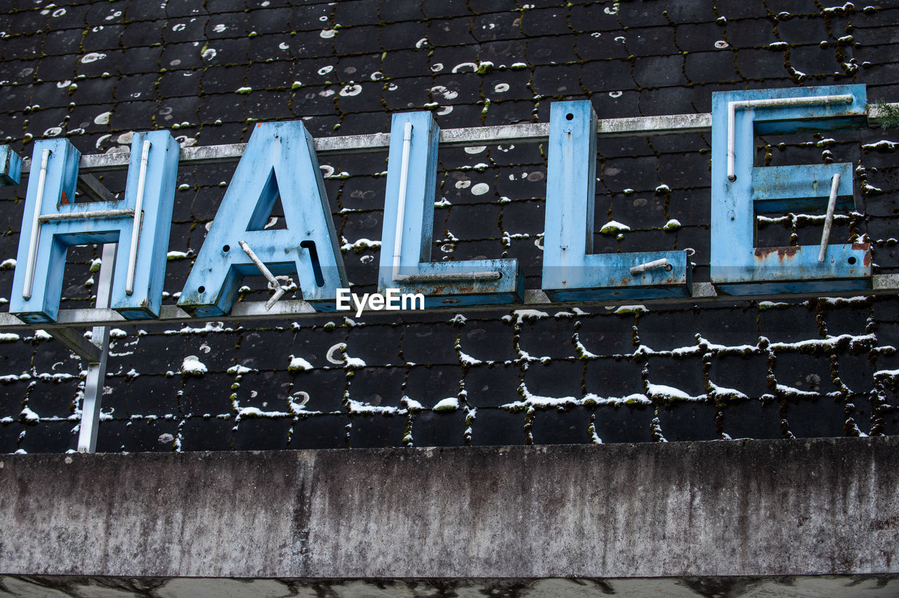 LOW ANGLE VIEW OF TEXT ON METAL WALL