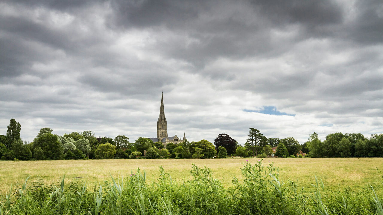 Scenic view of field against cloudy sky