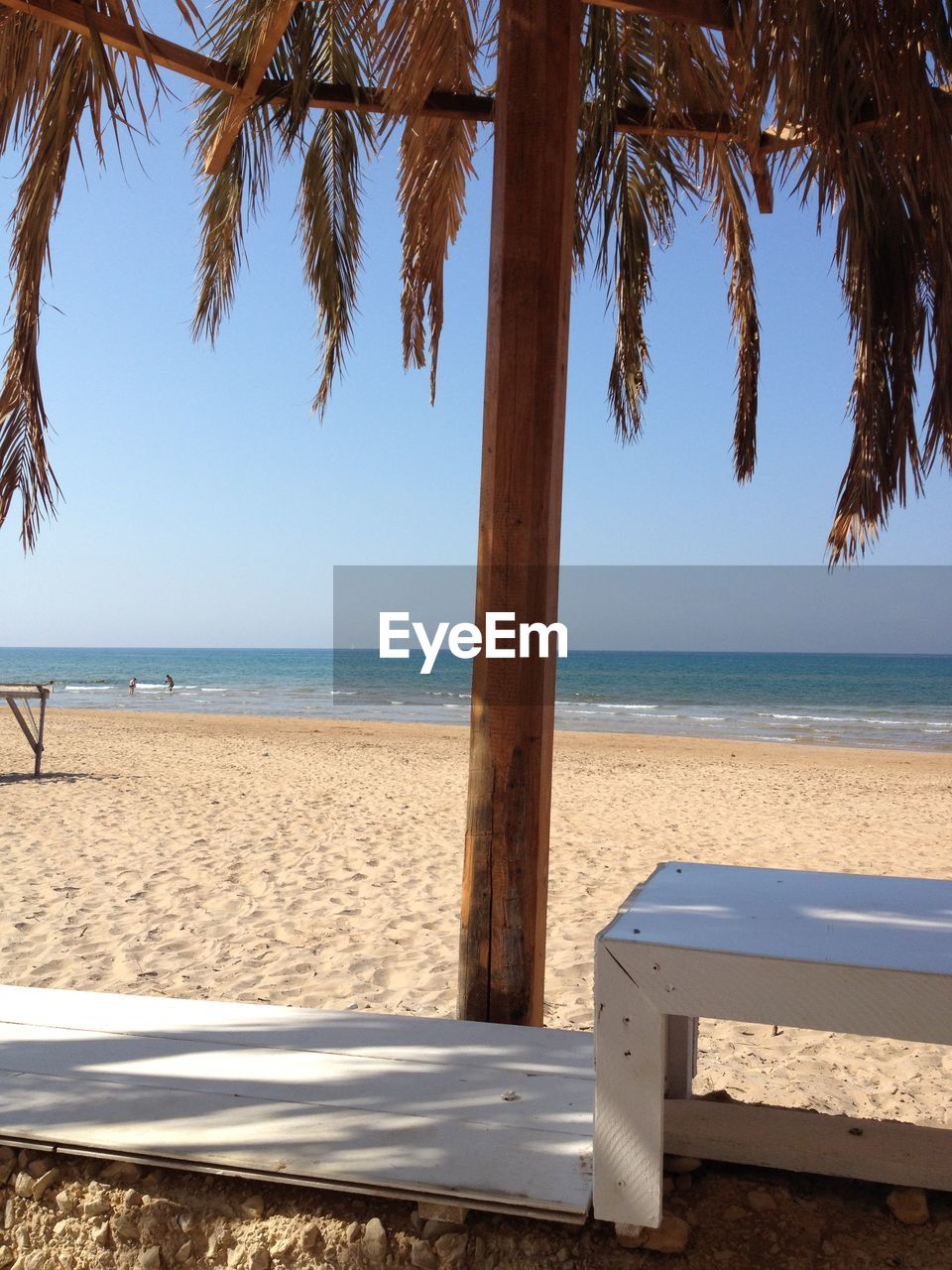 Wooden pole in beach against sea