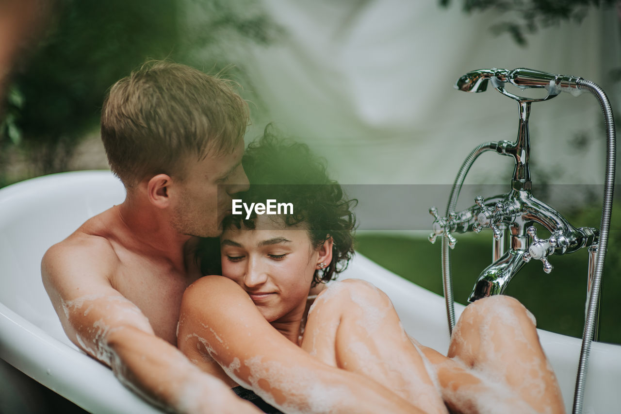 Couple in bathtub outdoors