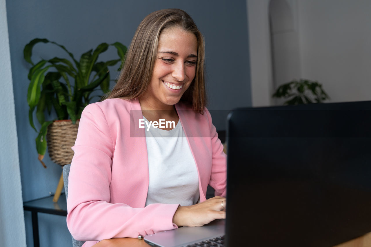 Smiling young woman using mobile phone