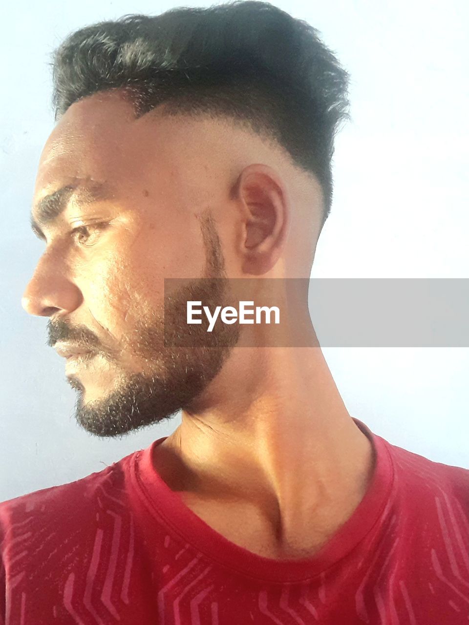 human hair, hairstyle, facial hair, one person, portrait, headshot, adult, beard, nose, human face, men, young adult, indoors, chin, looking, studio shot, casual clothing, looking away, human head, lifestyles, moustache, close-up, person, red, front view, serious, stubble, t-shirt, contemplation, forehead, black hair, human mouth