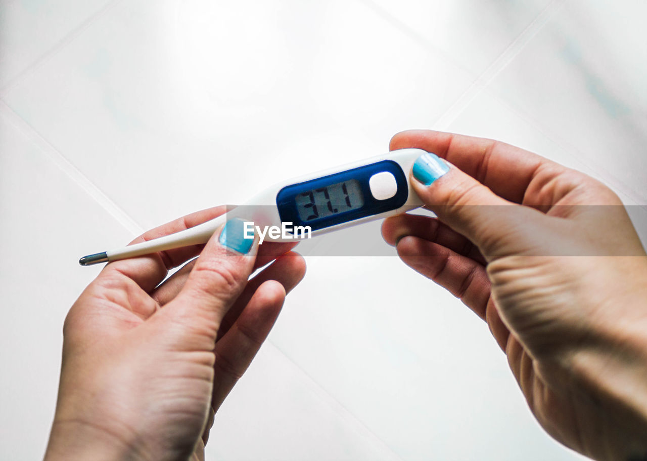 Female hands holding a thermometer