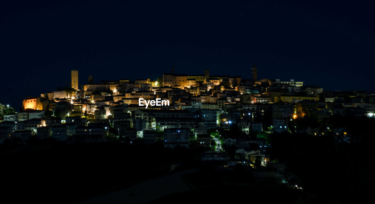 High angle view of illuminated buildings against clear sky at night