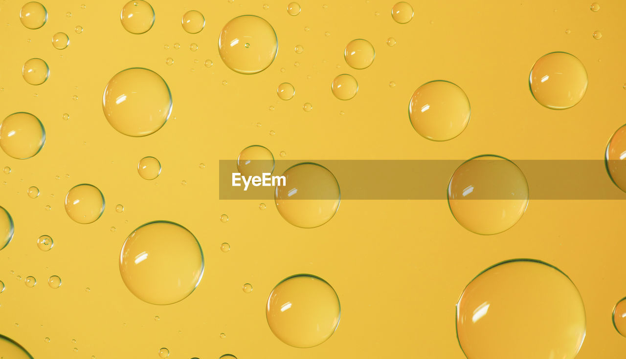 Full frame shot of bubbles on yellow background