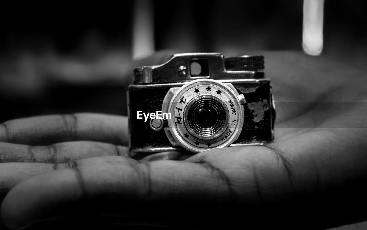 CLOSE-UP OF PERSON PHOTOGRAPHING CAMERA