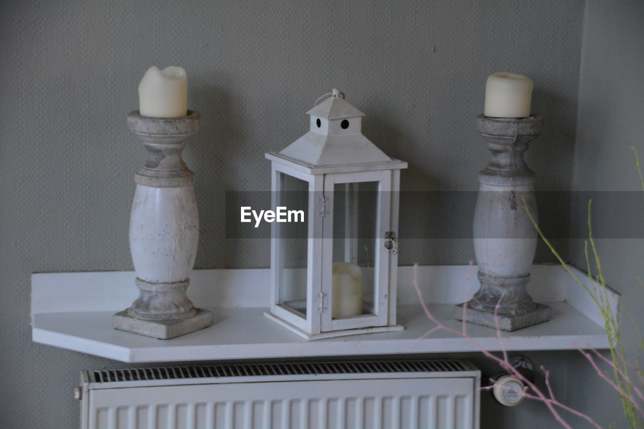 Close-up of lantern on table against the wall