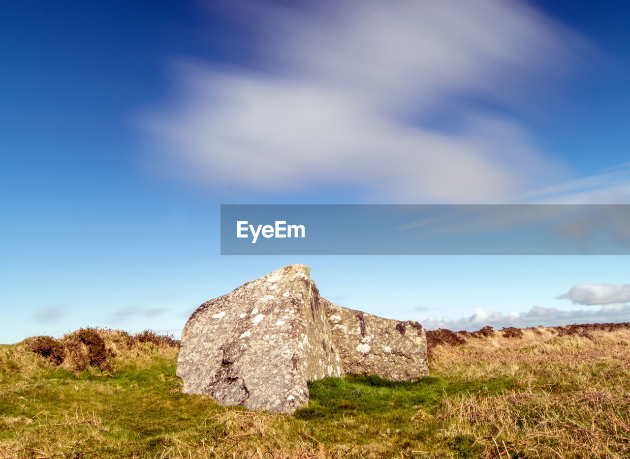 Rocks on field against sky