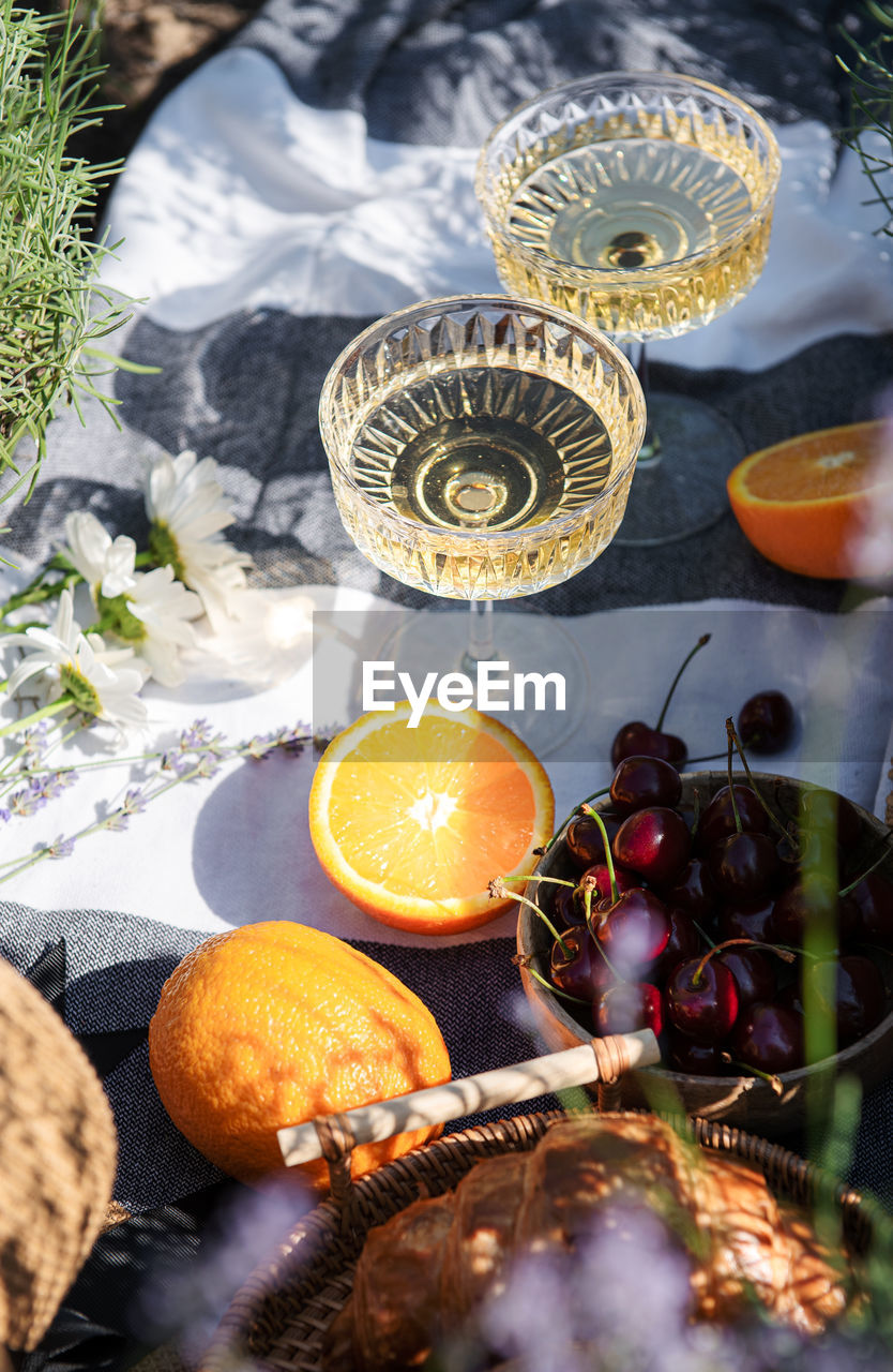 Summer picnic on a lavender field with champagne glasses and fruits