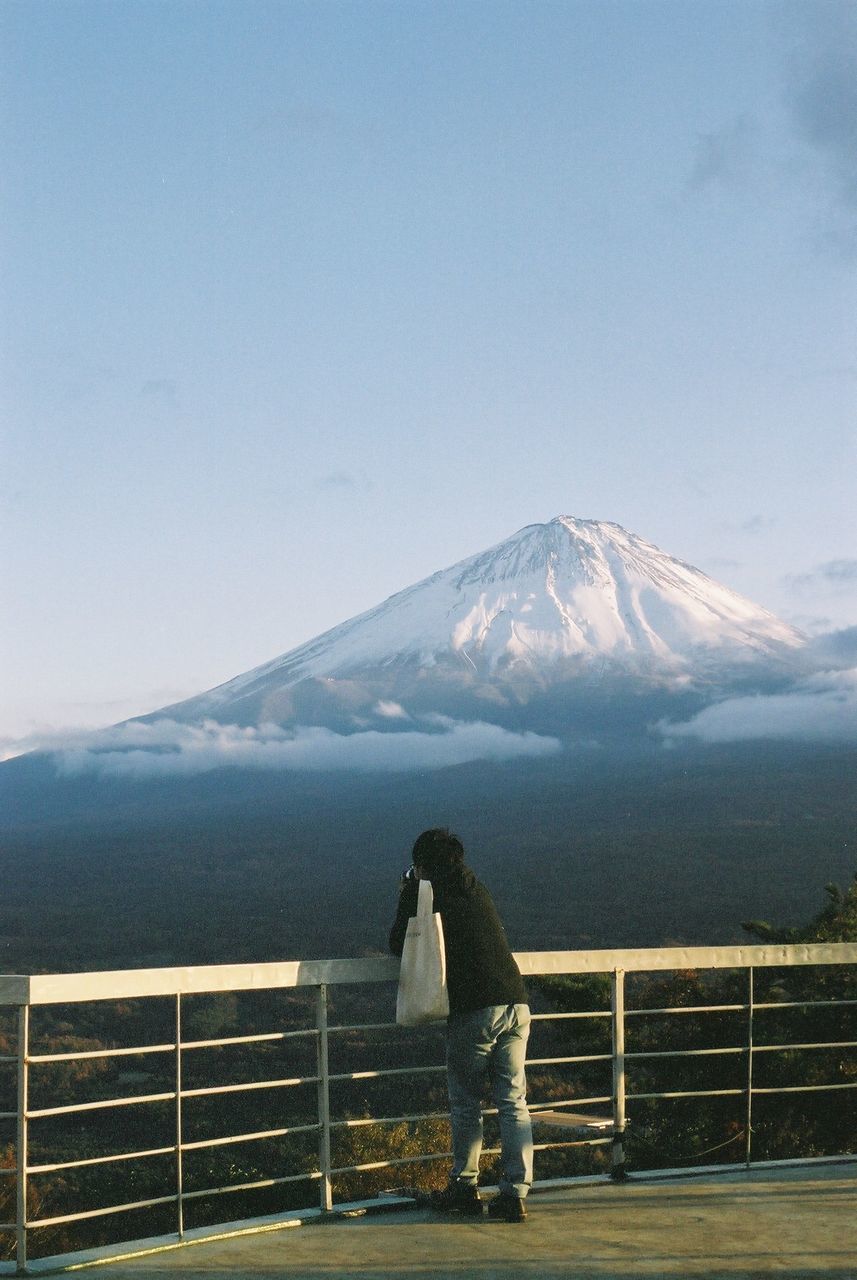 PERSON ON SNOWCAPPED MOUNTAIN AGAINST SKY