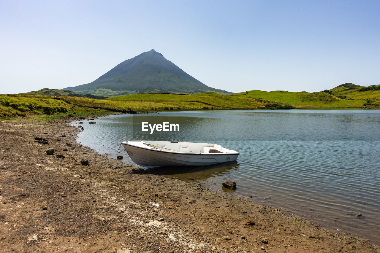 Boat on shore against clear sky