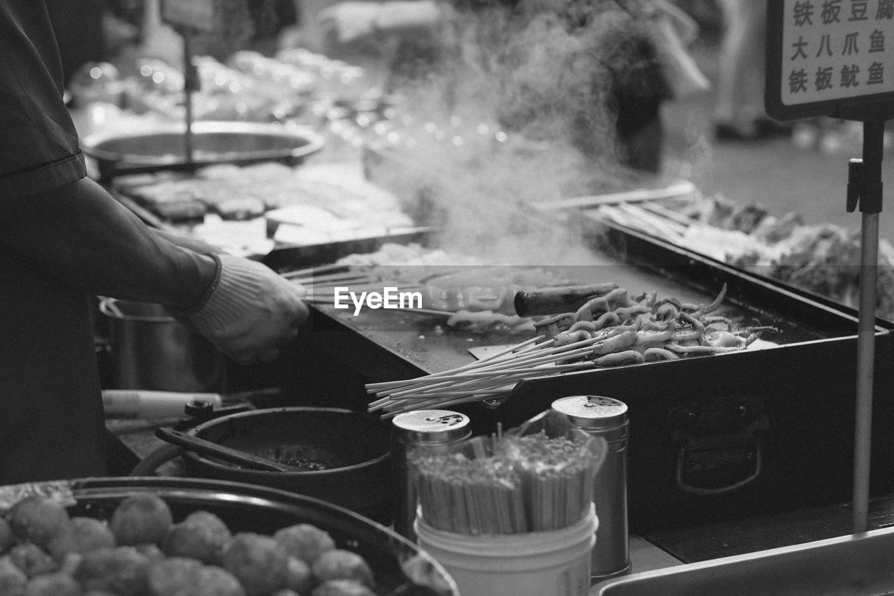 Cropped hand of man preparing food at market