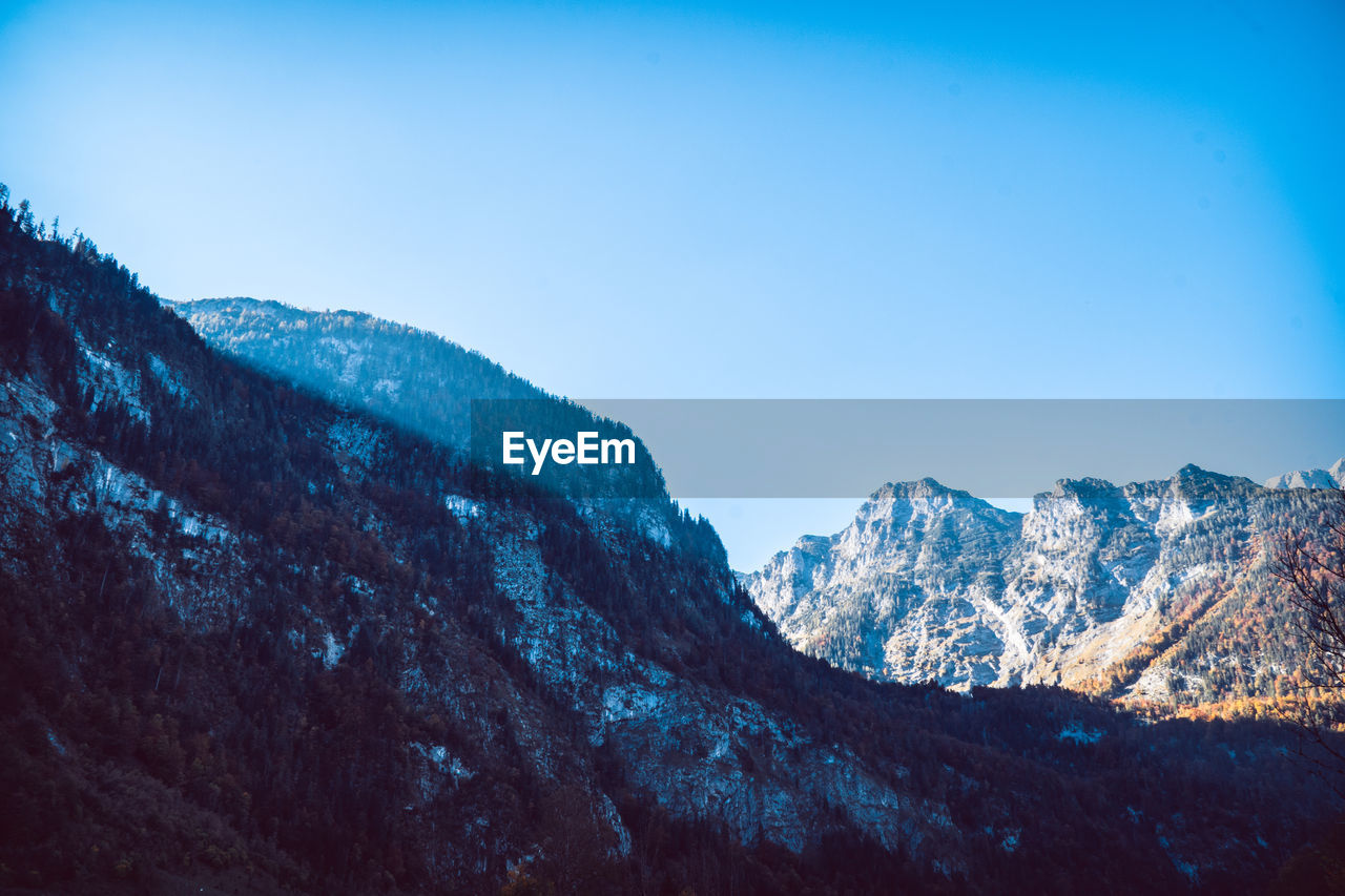 Scenic view of mountains against clear blue sky