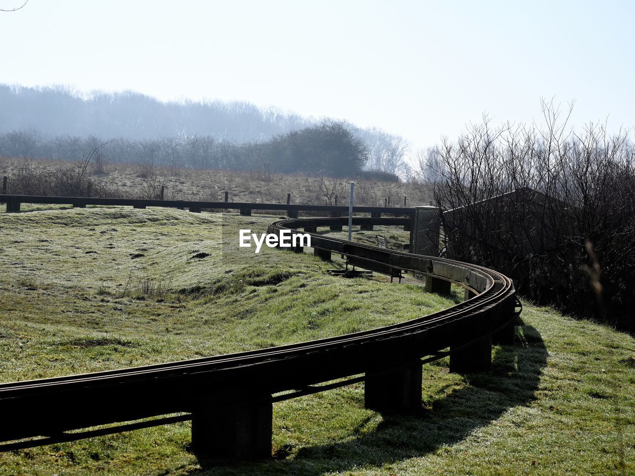 Bench on field against clear sky