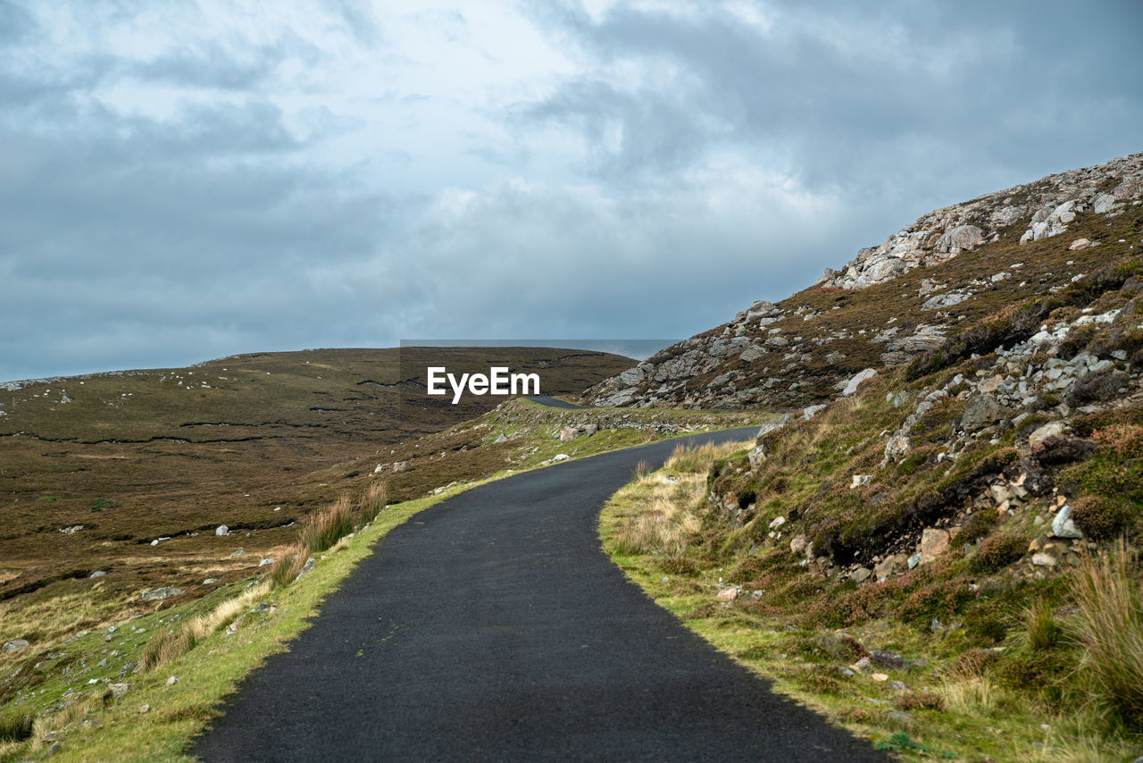 Empty road along landscape against sky