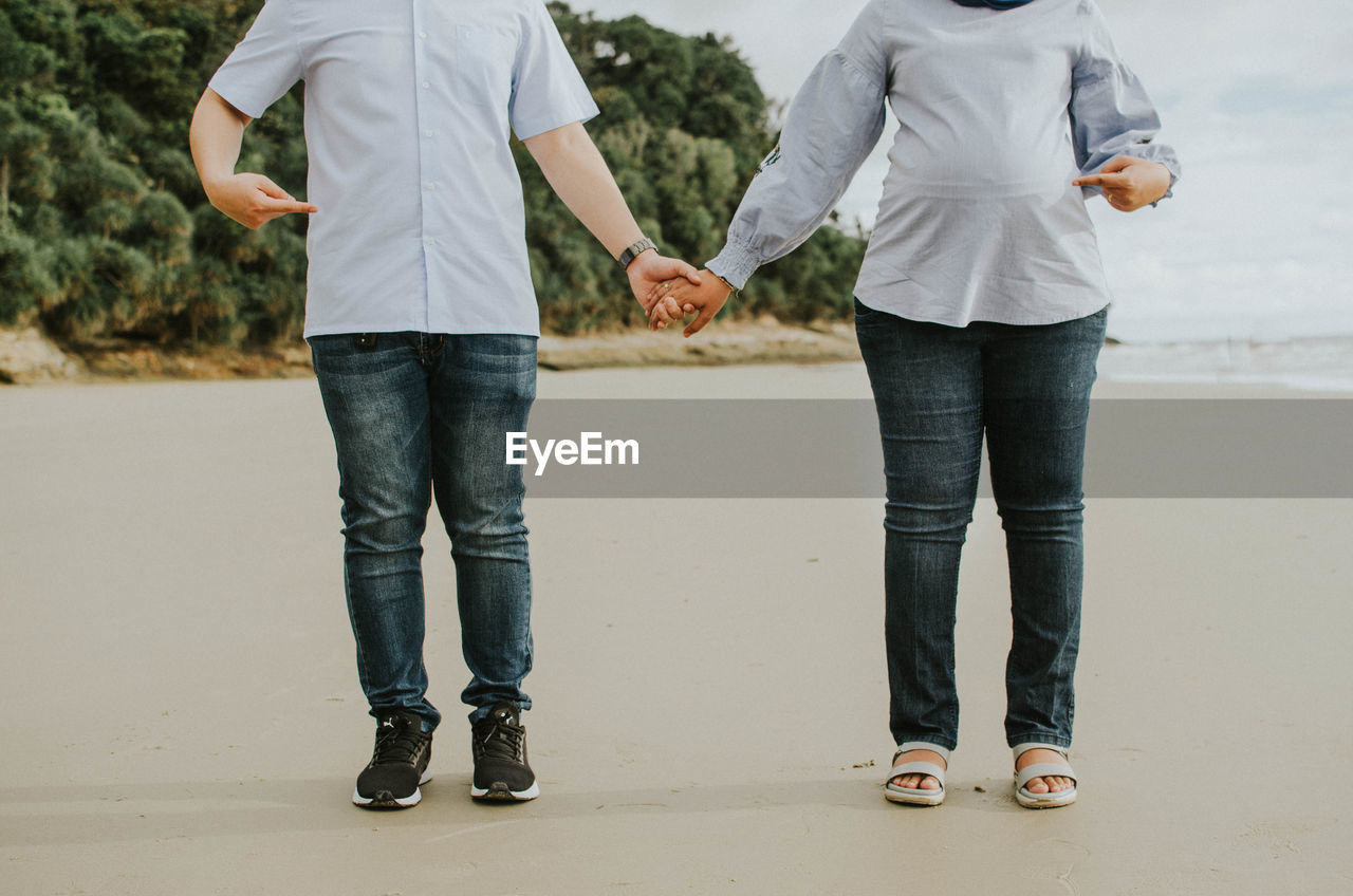Low section of couple standing outdoors