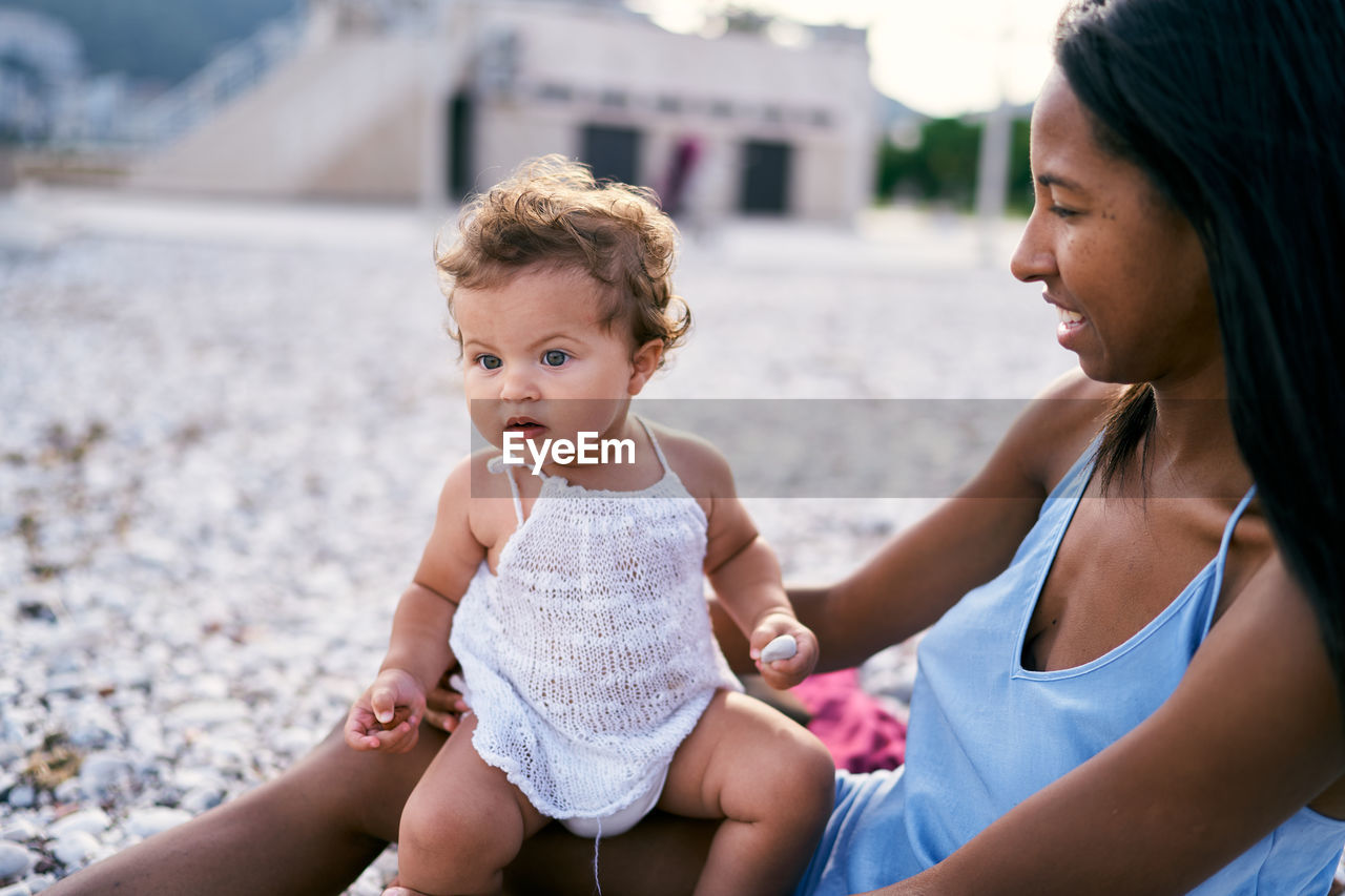 Mother and baby girl sitting outdoors