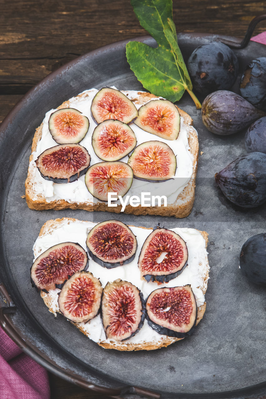 Bruschetta with soft ricotta with ripe figs served on a tray. vertical picture
