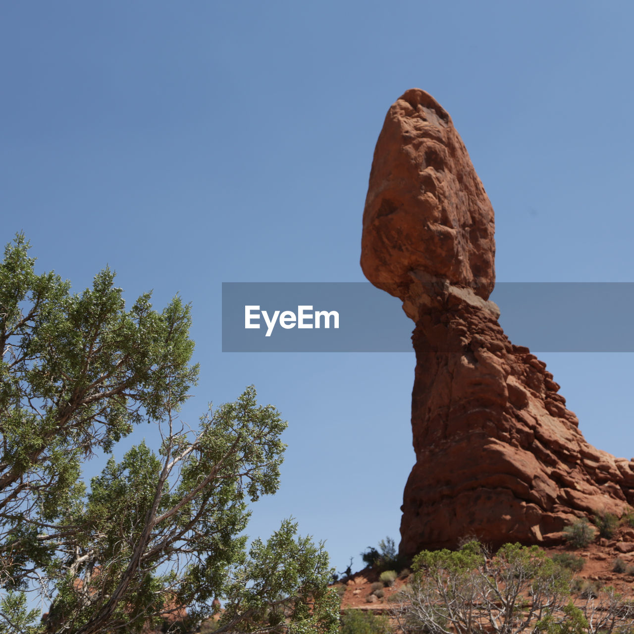 LOW ANGLE VIEW OF ROCK FORMATIONS AGAINST CLEAR BLUE SKY