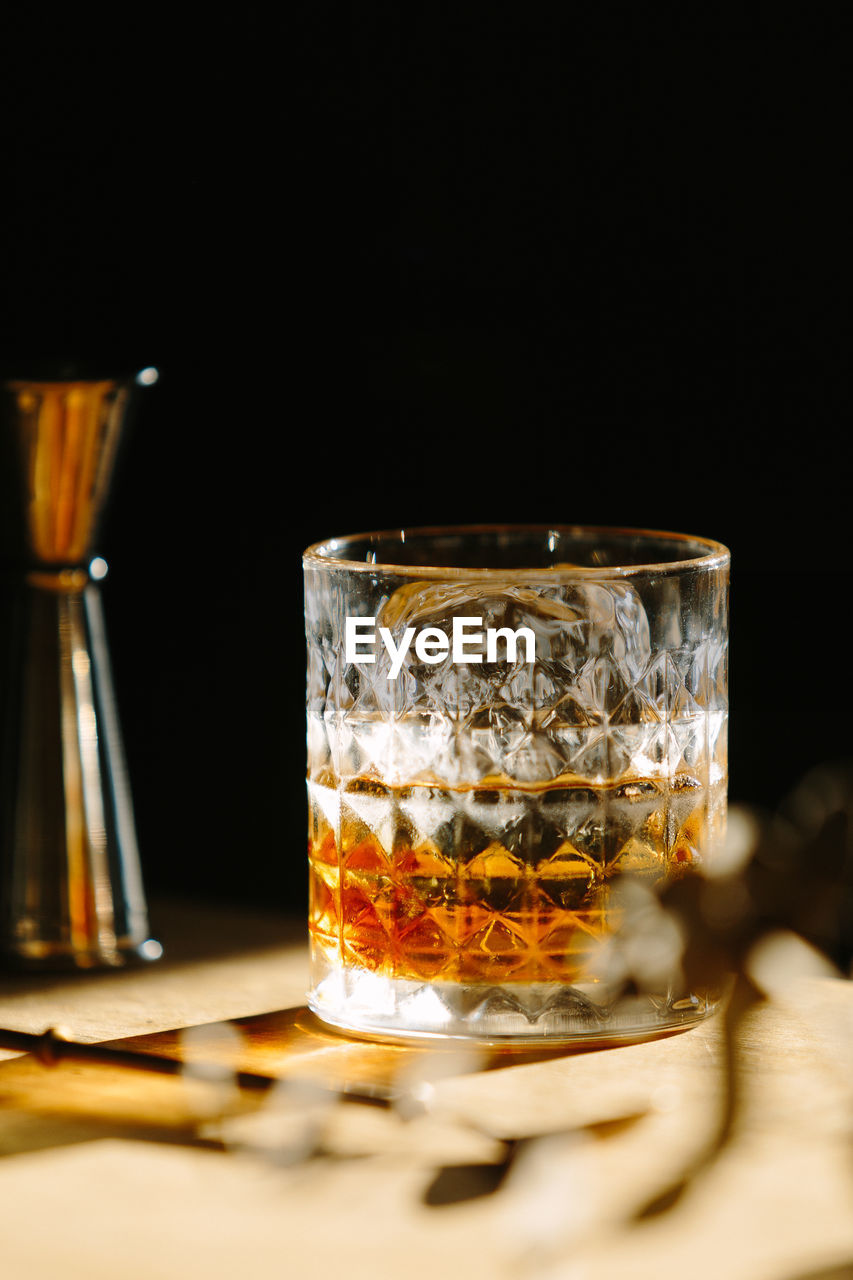 Close-up of glass with bourbon whiskey on table