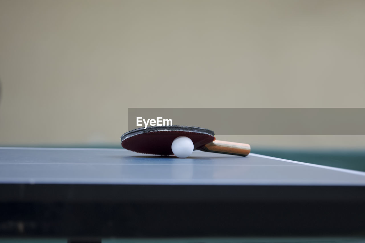 Table tennis racket and ball on table