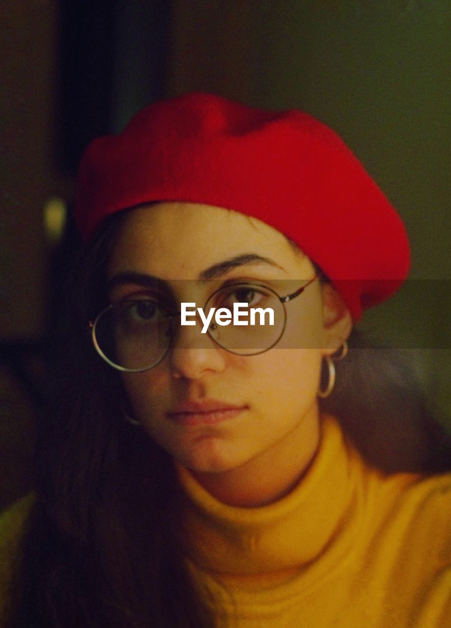 Portrait of young woman wearing eyeglasses and cap