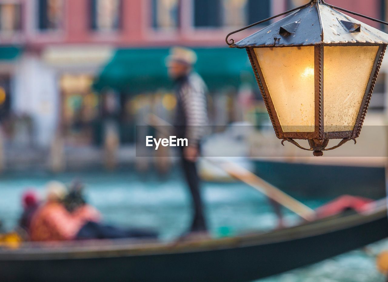 Close-up of illuminated lamp in canal in venice 