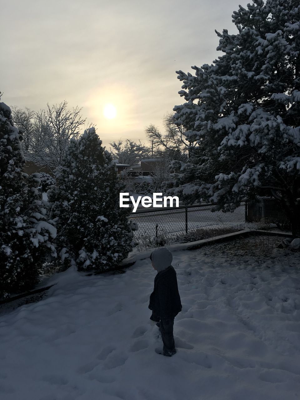 Child standing on snow during winter