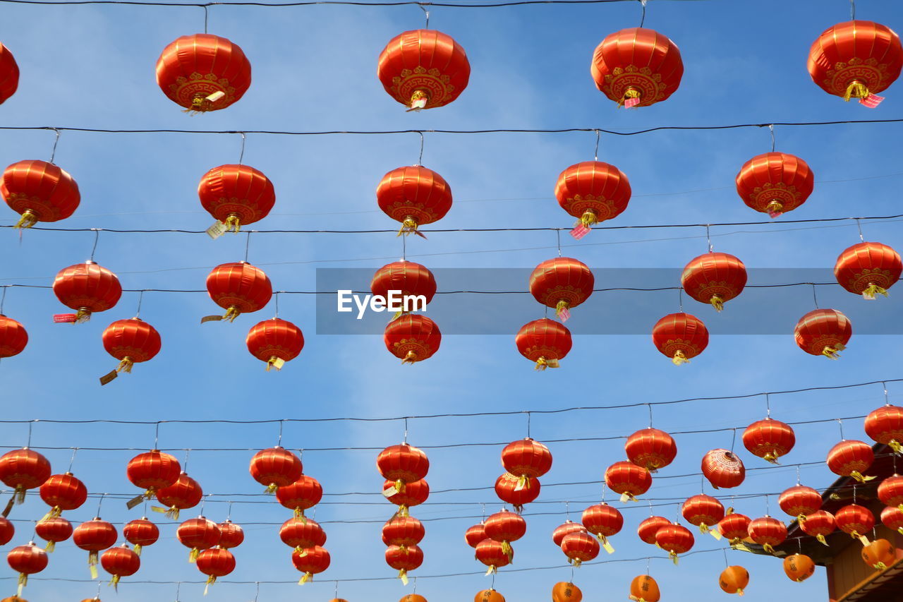 Low angle view of lanterns hanging against sky