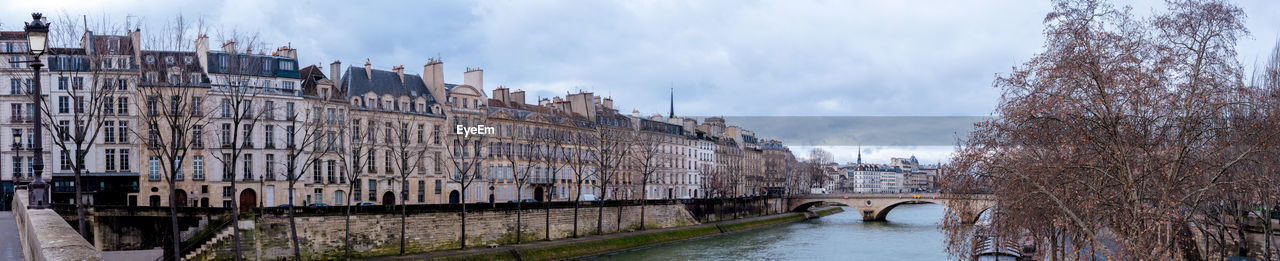 Bridge over river against cloudy sky