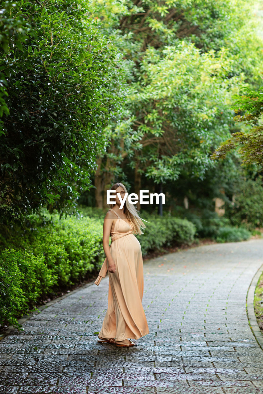 Rear view of woman standing against trees