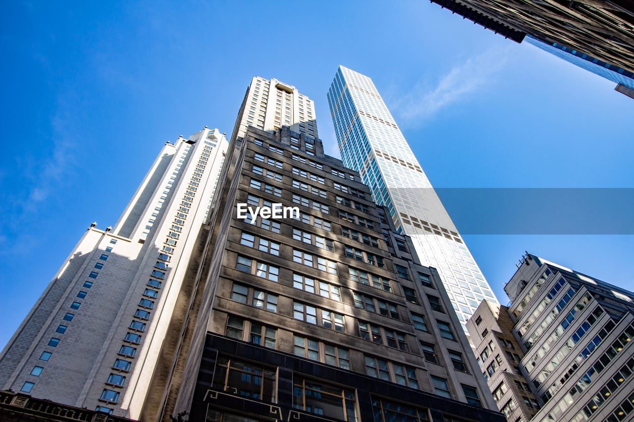Low angle view of modern buildings against clear blue sky