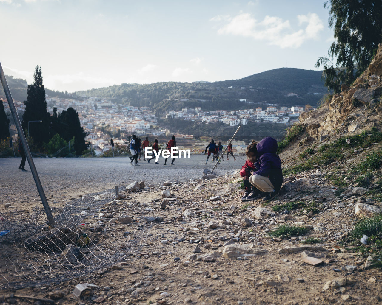 GROUP OF PEOPLE ON MOUNTAIN ROAD AGAINST SKY